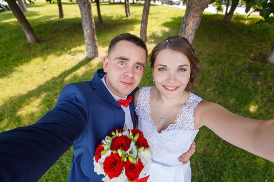 Beautiful bride and groom taking a selfie with outdoors