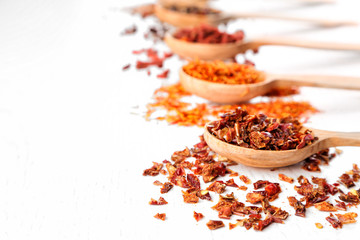 Spices in spoons on a wooden background