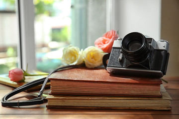 Vintage camera and beautiful roses on photo albums