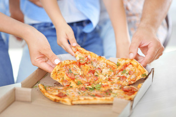 Obraz na płótnie Canvas Hands taking pizza from table, closeup