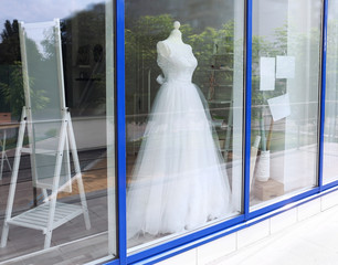 Beautiful wedding dress behind shop window