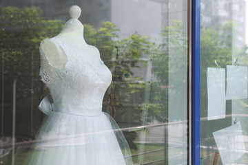 Beautiful wedding dress behind shop window