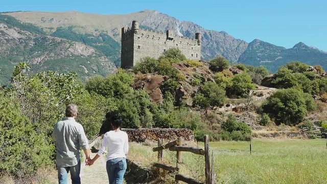 Châtillon, Aosta valley, Italy. Tourists taking a picture of medieval Castle of Ussel with mountains landscape and blue sky. Summer holidays, history and italian tourism destination