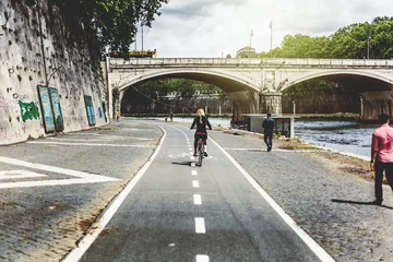 Türaufkleber Girl riding a bike over a bike path in lungotevere, close to Tiber river. Rome, Italy. © daviles