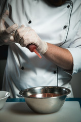 Cheerful bearded chef cook cooking while cooking meals in the kitchen