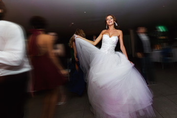 Fototapeta premium Smiling brunette bride dancing