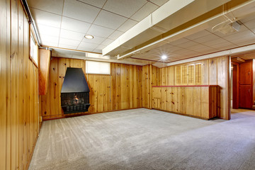 Empty room interior with wooden pannel trim walls and fireplace.