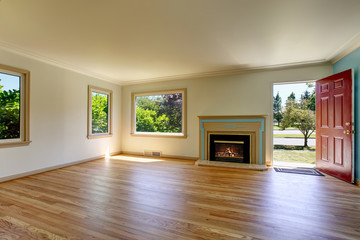 Open floor plan empty living room with polished hardwood floor.