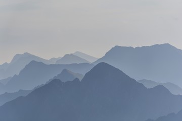 Silhouette of blue mountains in the fog. View of Moldoveanu peak, the highest peak from Romanian Carpathian Mountains range. Seamless background.