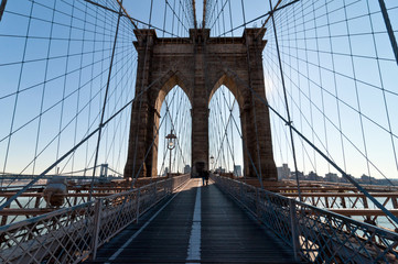 Walk across Brooklyn Bridge backlit