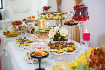 Different delicious desserts and cakes on table