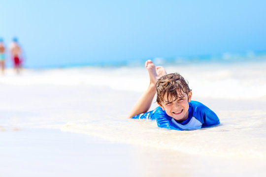 little blond kid boy having fun on tropical beach of Jamaica