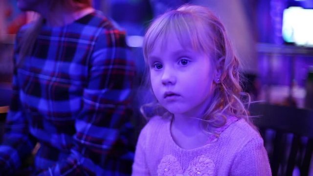 Beautiful small girl in a nightclub waiting start of the show.