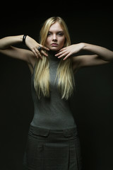 Fototapeta na wymiar Portrait of beautiful young blonde girl in black dress. 