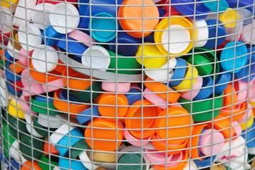 Colorful plastic caps collected in a recycle container