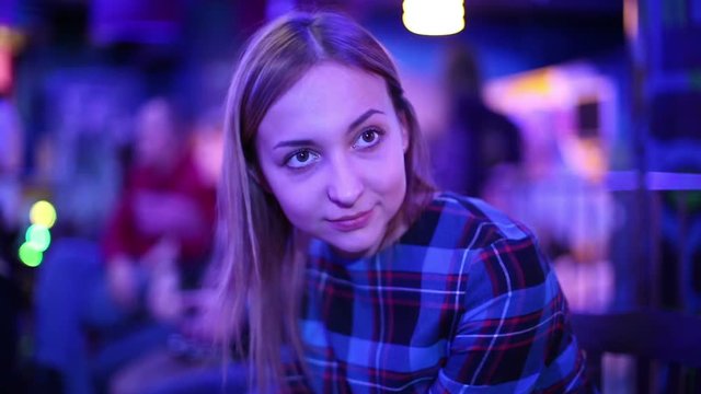 Beautiful young woman in a nightclub waiting start of the show.