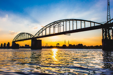 Destroyed iron bridge on the sunset background