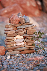 A small stone House construction with a tree in front of it isolated on beach background