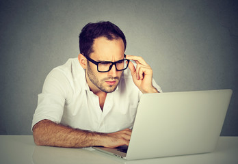 Worried businessman working on laptop computer
