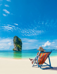 Woman relaxing in deck chair on the beach