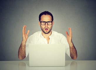 Stressed man looking at his laptop computer