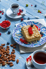 Pastry pie, tea, coffee and berries at blue rustic wood