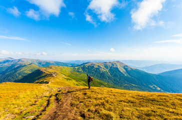 Traveler with backpack and mountain panorama. Traveler watching the sunrise from the mountain. Man admiring sunrise in the mountains. A young boy with a backpack to conquer the peak.