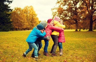 group of happy children hugging in autumn park