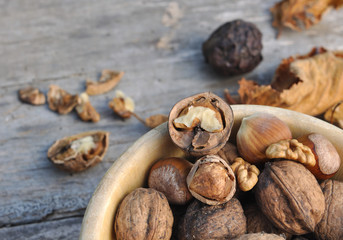 noix et noisettes décortiquées dans un bol sur fond en bois 