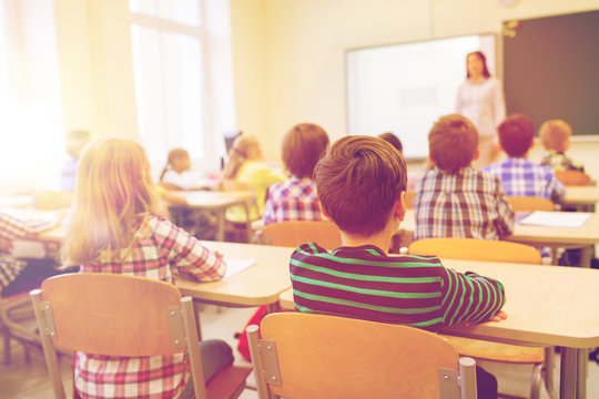 group of school kids and teacher in classroom