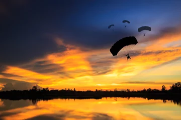 Tuinposter parachute at sunset silhouetted © comenoch