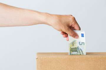 man putting euro money into donation box