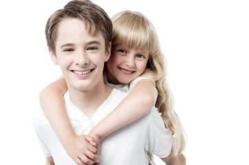 Young brother giving little sister piggyback ride