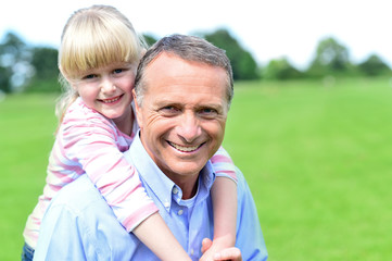 Fototapeta premium Daughter staying on her fathers back