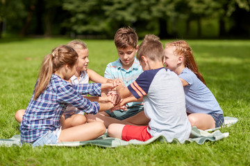 group of happy kids putting hands together