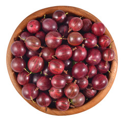 Fresh red gooseberry in a wooden bowl on a white