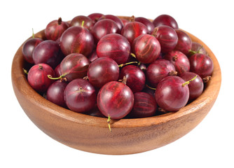 Fresh red gooseberry in a wooden bowl on a white
