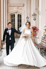 Beautiful bride and groom walking together and laughting outdoor
