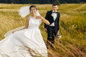 happy husband and wife walking together in field