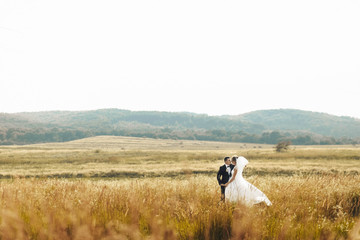happy husband and wife walking together in field