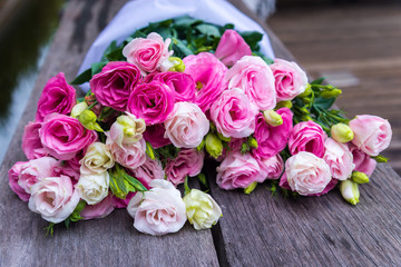 Beautiful bouquet of pink roses on wood background, outdoor