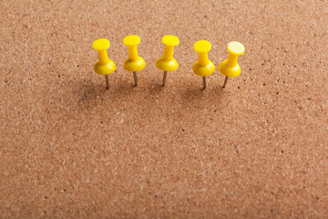 Group of thumbtacks pinned on corkboard
