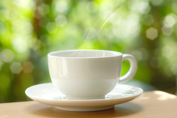 White cup coffee with nature background.