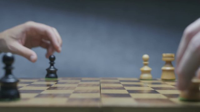 Two players prepering chess pieces before the game. Gradient gray background.
