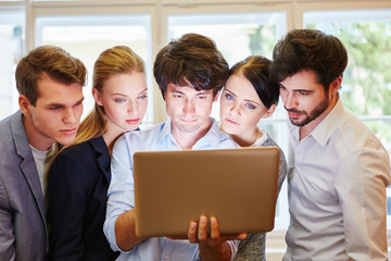 Business Team schaut auf Laptop