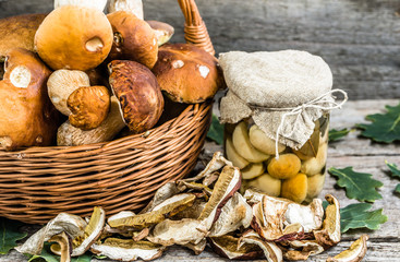 Porcini mushrooms pickled in jar and dried mushroom on rustic ba