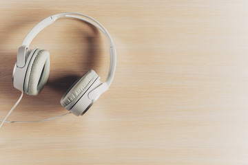 Headphones on wooden desk table.