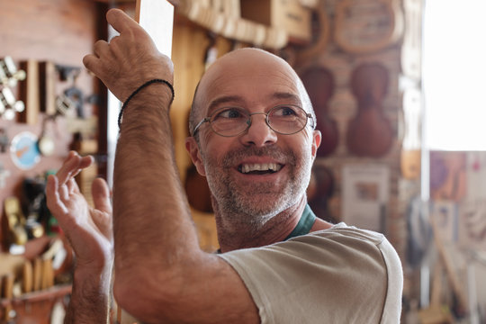 Violin maker checking sound of wood to be used for new instrumen