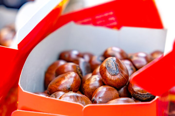 Paper package and heap of roast chestnut from the Thai street market