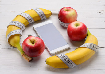 Fresh fruit: bananas and apples on a wooden table.